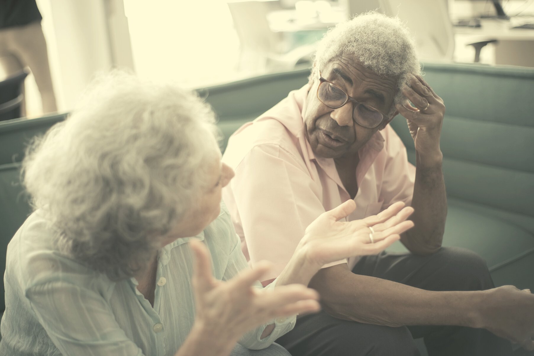 Elderly Man in Pink Dress Shirt Sitting Beside an Elderly Woman 